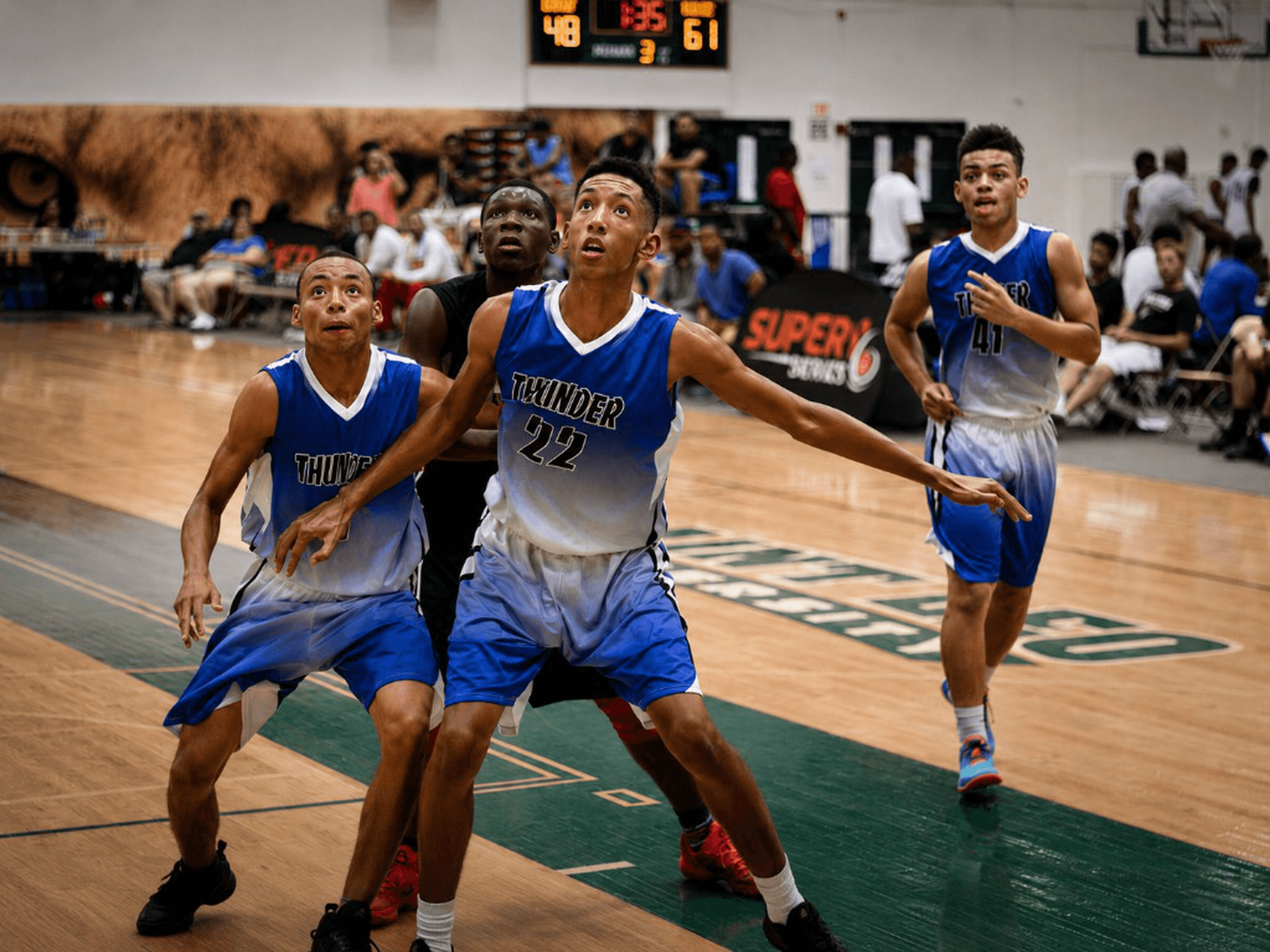 Thunder athletes boxing out under the scoreboard at a Super6 Series LLC elite weekend.