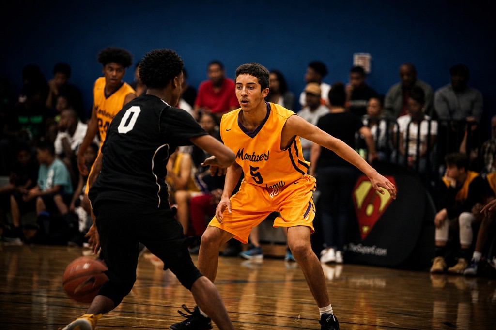 Super6 tournament basketball — drive defended one-on-one on the hardwood.